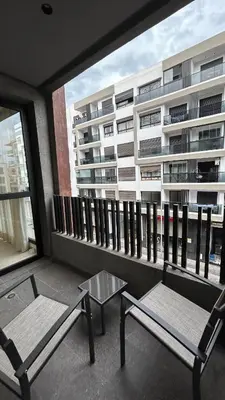 a balcony with two chairs and a table and a building at Central Casablanca Cozy Home in Casablanca