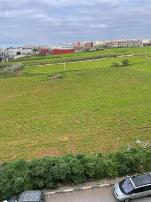 two cars parked in front of a field of grass at Apparemment Moderne à Temara in Temara