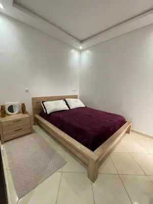 a bedroom with a bed and a night stand at Apparemment Moderne à Temara in Temara