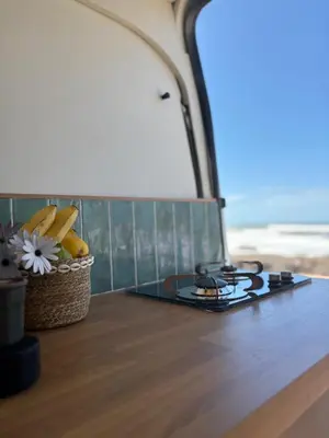 a stove top on a table with a basket of fruit at Van aménagé tout confort in Tamaris