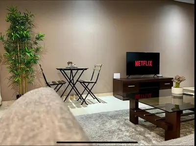 a living room with a tv and a table with a table at Anfa City in Casablanca