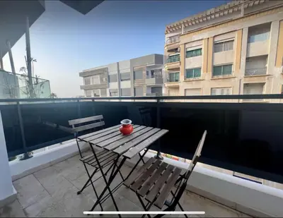 a wooden table and two chairs on a balcony at Anfa City in Casablanca