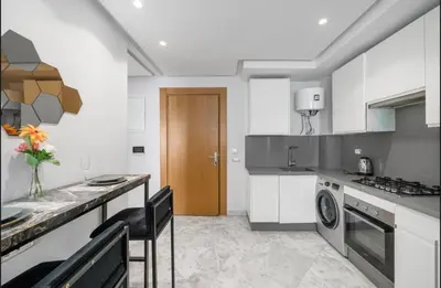 a kitchen with a counter and a table with chairs at Seabreeze home on the Corniche in Casablanca