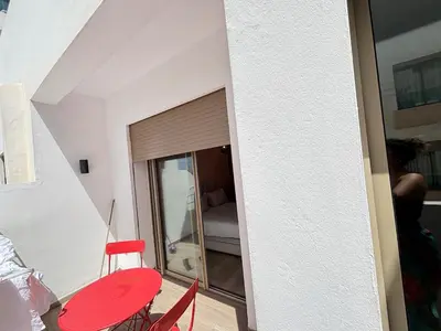 a room with a red table and chairs and a bedroom at Seabreeze home on the Corniche in Casablanca