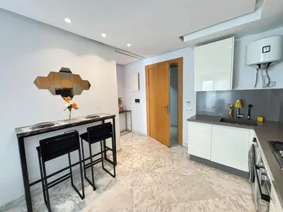 a kitchen with a counter and some stools in it at Seabreeze home on the Corniche in Casablanca