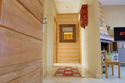 a hallway with a wooden door and a mirror at La Coralline Pied dans l'eau, Vue apaisante in Casablanca