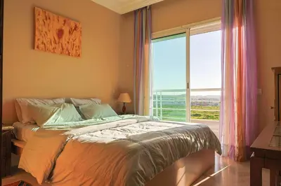 a bedroom with a bed and a large window at La Coralline Pied dans l'eau, Vue apaisante in Casablanca