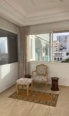 a living room with a chair and a window at High Standing Apartment in Casablanca in Casablanca