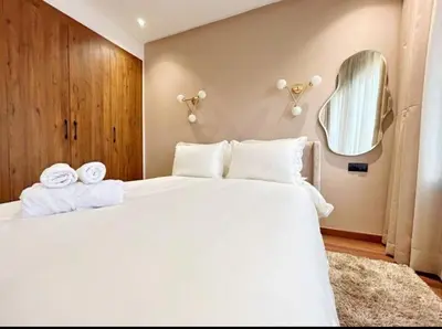 a bedroom with a large white bed with a mirror at MR9-03 Nice corner in the heart of Casa in Casablanca