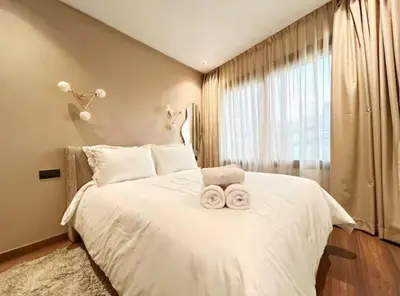 a bedroom with a large white bed with two towels on it at MR9-03 Nice corner in the heart of Casa in Casablanca