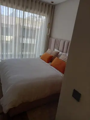 a bedroom with a bed with orange pillows and a window at Elegance Comfort Terrace in the heart of Princesses in Maarif