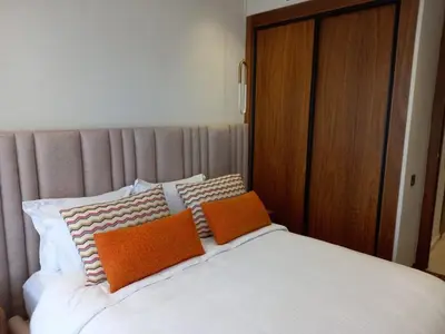a bed with two orange pillows on top of it at Elegance Comfort Terrace in the heart of Princesses in Maarif