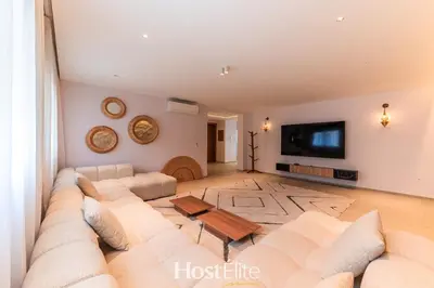 a living room with a large couch and a flat screen tv at Exceptional Private Room 2 SandRose in Casablanca