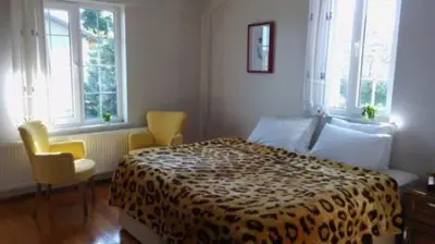 a bedroom with a bed and two chairs and windows at Apparemment d été in Tamaris