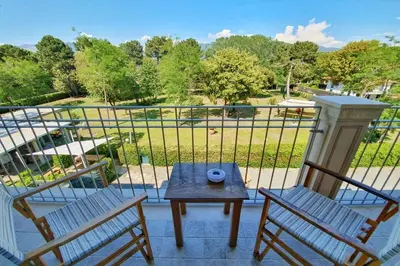 two chairs and a table on a balcony with a view of a park at Apparemment d été in Tamaris