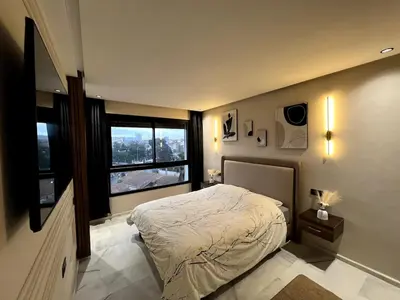 a bedroom with a bed and a large window at Apartment - Casablanca - Palmiers in Casablanca
