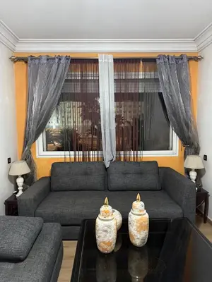 a living room with a couch and two vases on a table at Comfortable apartment in Casablanca Assalam in Casablanca