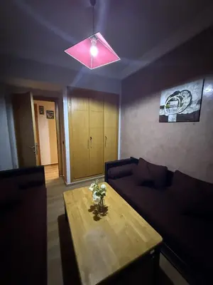 a living room with a table and a pink light at Comfortable apartment in Casablanca Assalam in Casablanca