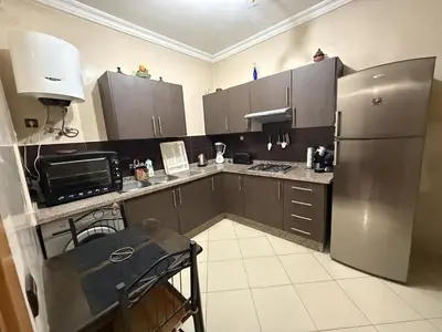 a kitchen with a stainless steel refrigerator and cabinets at Comfortable apartment in Casablanca Assalam in Casablanca