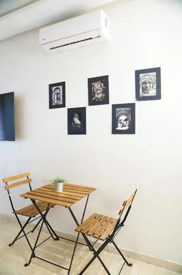 a table and two chairs in front of a wall with pictures at Contemporary Moroccan elegance in the heart of Casa in Casablanca