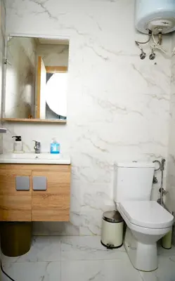 a bathroom with a toilet and a sink and a mirror at Contemporary Moroccan elegance in the heart of Casa in Casablanca
