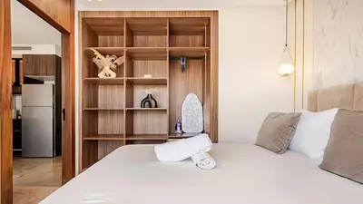 a bedroom with a white bed and a refrigerator at Dynasty Estate Luxury Apartments in Palmiers, Casablanca in Maarif