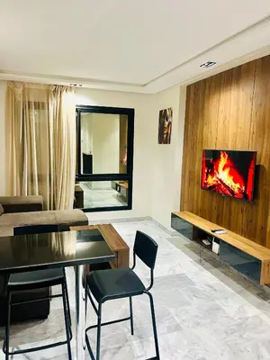 a living room with a table and a tv on a wall at Rare Living in Casablanca