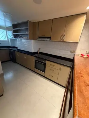 a kitchen with brown cabinets and a counter top at Beautiful modern duplex - comfortable, good location in Casablanca