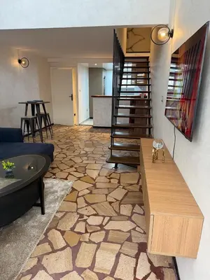 a living room with a couch and a stair case at Beautiful modern duplex - comfortable, good location in Casablanca