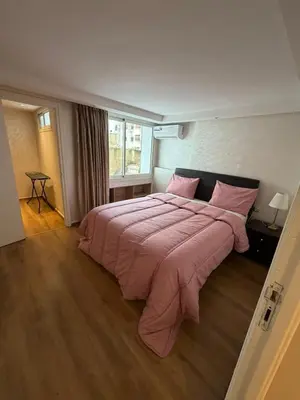 a bedroom with a large bed with pink blankets at Beautiful modern duplex - comfortable, good location in Casablanca