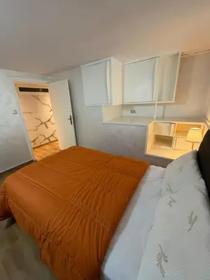 a bedroom with an orange bed and white cabinets at Beautiful modern duplex - comfortable, good location in Casablanca