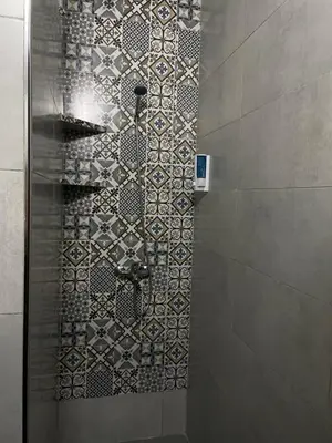 a bathroom with a shower with a mosaic tile wall at Cozy getaway for a perfect stay in Rabat