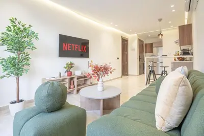 a living room with a couch and a table at Dynasty Estate Apartment Maarif with Parking Netflix Air Conditioning in Casablanca
