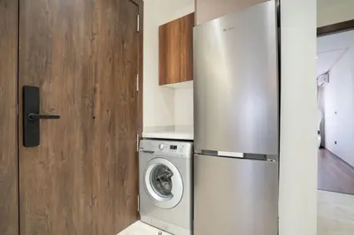 a kitchen with a refrigerator and a washing machine at Dynasty Estate Apartment Maarif with Parking Netflix Air Conditioning in Casablanca