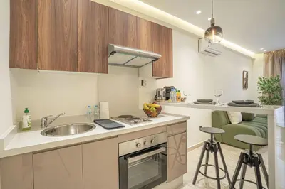 a kitchen with a sink and a counter with stools at Dynasty Estate Apartment Maarif with Parking Netflix Air Conditioning in Casablanca