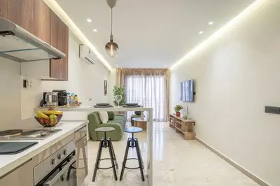 a kitchen with white counters and green stools at Dynasty Estate Apartment Maarif with Parking Netflix Air Conditioning in Casablanca
