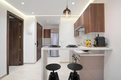 a kitchen with two stools at a kitchen counter at Dynasty Estate Apartment Maarif with Parking Netflix Air Conditioning in Casablanca