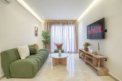 a living room with a green couch and a table at Dynasty Estate Apartment Maarif with Parking Netflix Air Conditioning in Casablanca