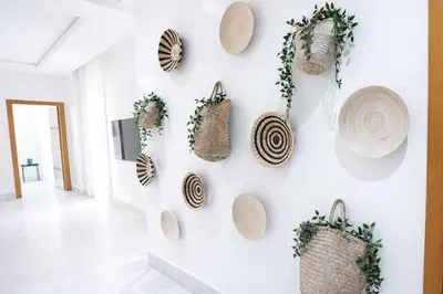 a wall with straw hats and baskets on it at Appartement Lumineux à Racine, Bohème Chic in Casablanca