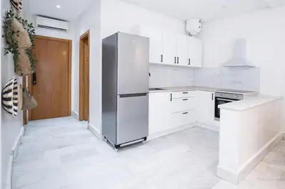 a kitchen with white cabinets and a refrigerator at Appartement Lumineux à Racine, Bohème Chic in Casablanca