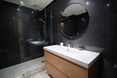 a bathroom with a sink and a mirror and a shower at Appartement Lumineux à Racine, Bohème Chic in Casablanca