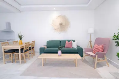 a living room with a green couch and a table at Appartement Lumineux à Racine, Bohème Chic in Casablanca