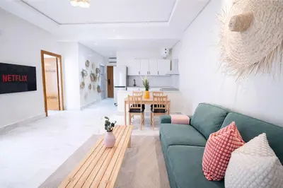 a living room with a green couch and a table at Appartement Lumineux à Racine, Bohème Chic in Casablanca