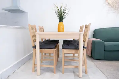 a wooden table with four chairs and a vase on top at Appartement Lumineux à Racine, Bohème Chic in Casablanca