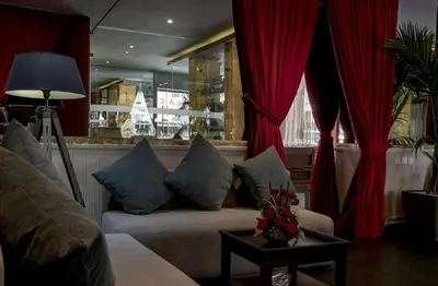 a living room with a couch and red curtains at Le Sphinx Boutique Hôtel in Mohammedia