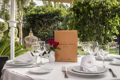 a table with plates and glasses and a box on it at Le Sphinx Boutique Hôtel in Mohammedia