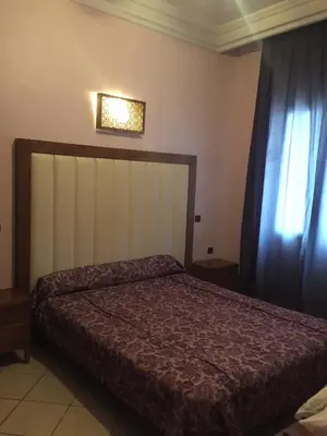 a bedroom with a bed and a window at Hotel Boustane in Casablanca