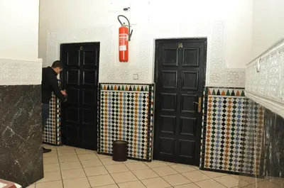 a man standing in front of two black doors at Hotel Boustane in Casablanca
