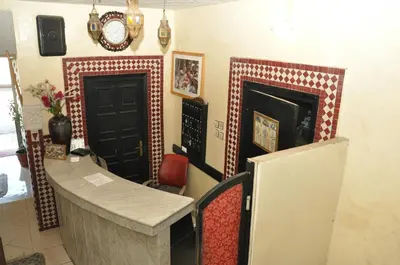 a kitchen with a counter and a refrigerator and a clock at Hotel Boustane in Casablanca