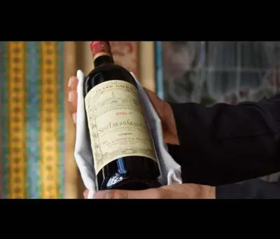 a person is holding a bottle of wine at Soundouss Hotel in Rabat